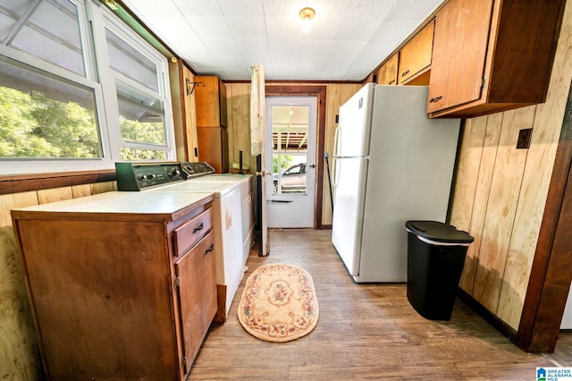 580 3rd St SW, Ashland, AL 36251 - kitchen featuring freestanding refrigerator, wooden walls, light wood finished floors, washer and clothes dryer, and brown cabinets