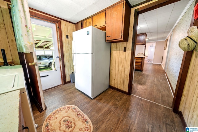 580 3rd St SW, Ashland, AL 36251 - kitchen with freestanding refrigerator, dark wood finished floors, ornamental molding, wood walls, and brown cabinetry
