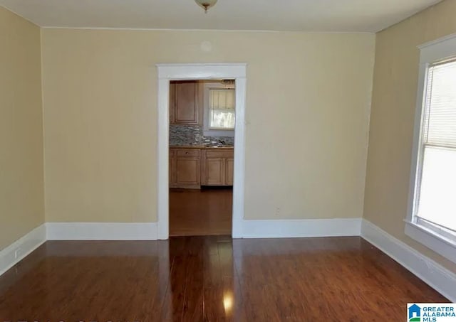 8405 3rd Ave S, Birmingham, AL 35206 - unfurnished room with dark wood-style floors, healthy amount of natural light, and baseboards