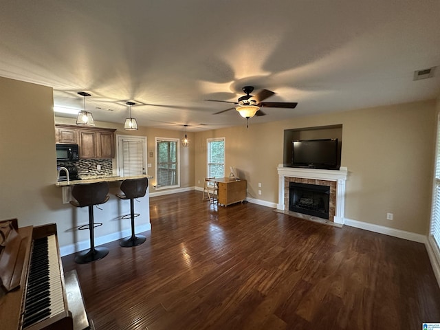 21131 Delmar Dr, Lake View, AL 35111 - unfurnished living room with dark wood-style flooring, a fireplace, and a ceiling fan