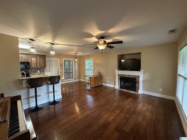 21131 Delmar Dr, Lake View, AL 35111 - unfurnished living room with a tile fireplace, dark wood-type flooring, and a ceiling fan