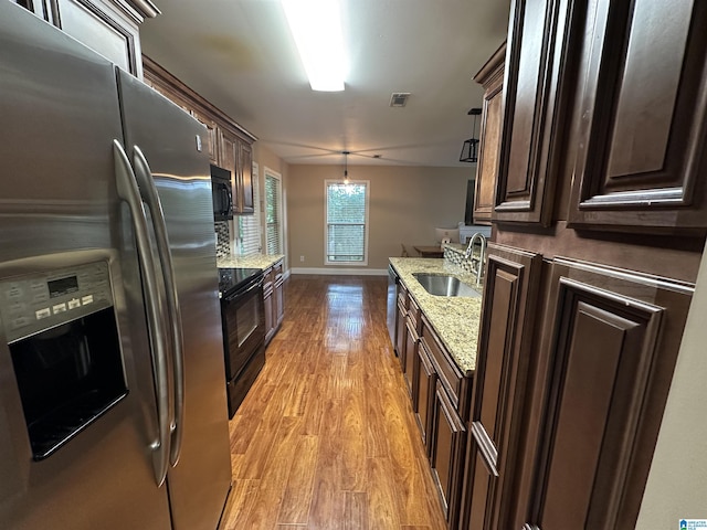21131 Delmar Dr, Lake View, AL 35111 - kitchen with black appliances, light wood-style floors, dark brown cabinetry, and light stone counters