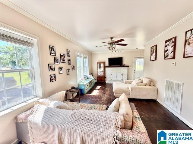 1005 4th Ave N, Clanton, AL 35045 - living area featuring ornamental molding, dark wood-style floors, a ceiling fan, and baseboards