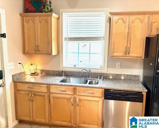 1005 4th Ave N, Clanton, AL 35045 - kitchen featuring stainless steel dishwasher, a sink, freestanding refrigerator, and light brown cabinetry