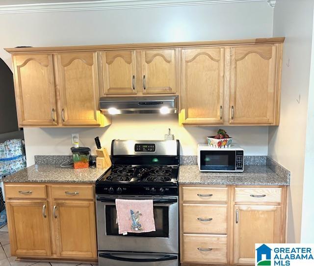 1005 4th Ave N, Clanton, AL 35045 - kitchen featuring stainless steel range with gas cooktop, under cabinet range hood, black microwave, and light brown cabinets