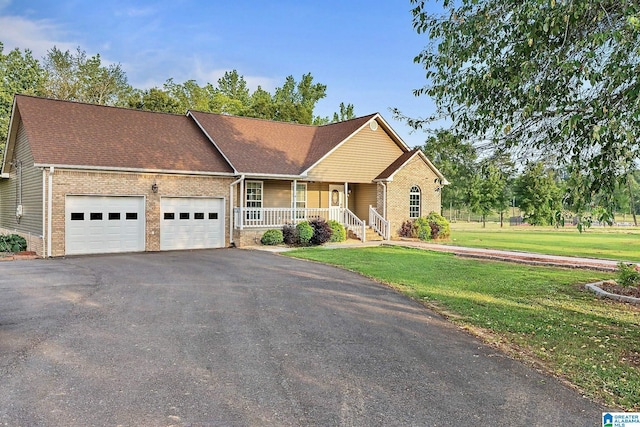 159 Williams Rd, Cullman, AL 35057 - ranch-style house with covered porch, brick siding, an attached garage, asphalt driveway, and a front yard