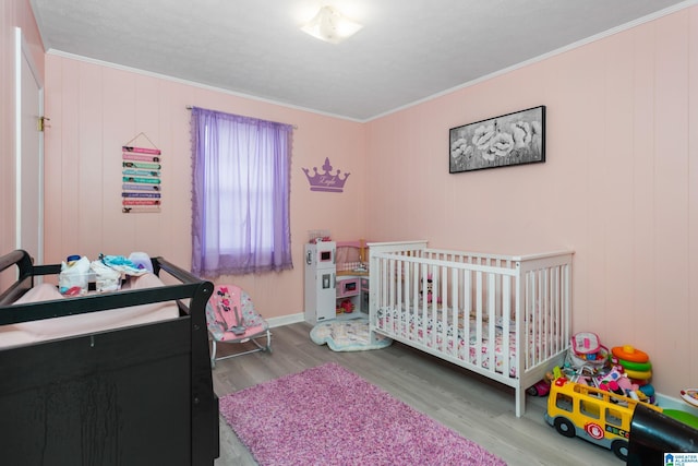 4507 Charles Ave, Anniston, AL 36206 - bedroom featuring wood finished floors, crown molding, a nursery area, and baseboards