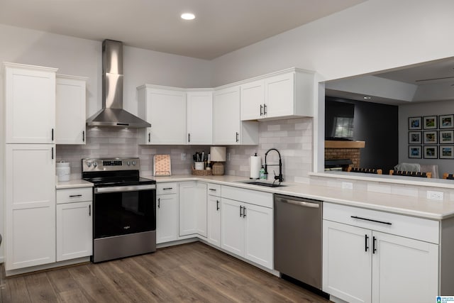 5883 William O Ln, Gardendale, AL 35071 - kitchen featuring stainless steel appliances, wall chimney range hood, a sink, a peninsula, and light countertops