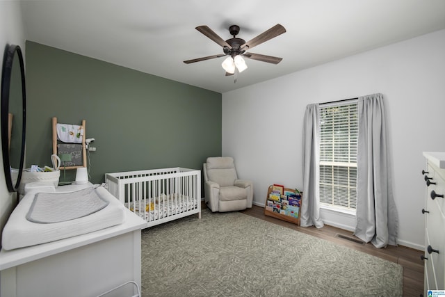 5883 William O Ln, Gardendale, AL 35071 - bedroom featuring wood finished floors, a crib, a ceiling fan, and baseboards