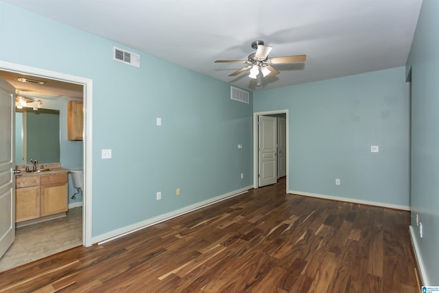 401 20th St S Unit 322, Birmingham, AL 35233 - unfurnished bedroom featuring a sink, wood finished floors, baseboards, and ensuite bathroom