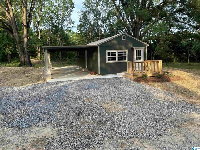 140 County Road 603, Hanceville, AL 35077 - view of front of property featuring gravel driveway, an attached carport, view of wooded area, and a deck