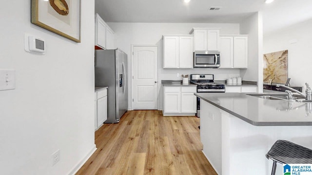 2300 Surry Dr SW, Cullman, AL 35055 - kitchen featuring stainless steel appliances, light wood-style flooring, white cabinetry, and a sink