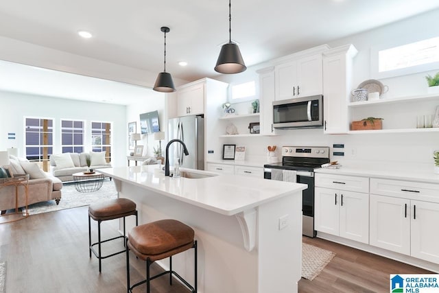 157 Shiloh Creek Dr, Calera, AL 35040 - kitchen with appliances with stainless steel finishes, open shelves, a sink, dark wood finished floors, and a breakfast bar area