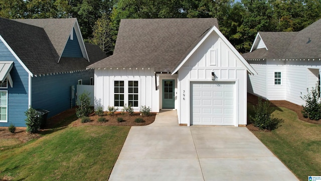 157 Shiloh Creek Dr, Calera, AL 35040 - view of front of property with board and batten siding, an attached garage, driveway, a front lawn, and roof with shingles