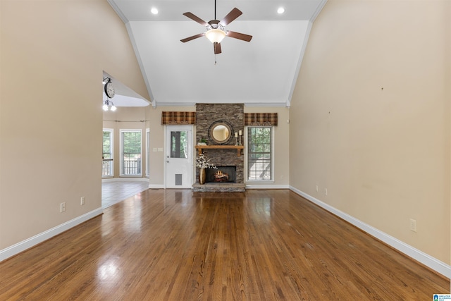 22582 Iron Masters Loop, Mccalla, AL 35111 - unfurnished living room featuring a ceiling fan, baseboards, high vaulted ceiling, wood finished floors, and a stone fireplace