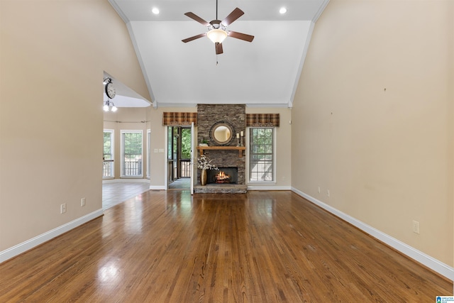22582 Iron Masters Loop, Mccalla, AL 35111 - unfurnished living room with a ceiling fan, baseboards, a stone fireplace, high vaulted ceiling, and wood finished floors
