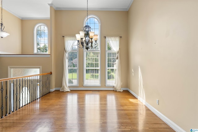 22582 Iron Masters Loop, Mccalla, AL 35111 - unfurnished dining area featuring a chandelier, wood finished floors, crown molding, plenty of natural light, and baseboards