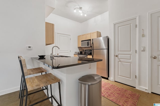 401 20th St S Unit 119, Birmingham, AL 35233 - kitchen with appliances with stainless steel finishes, a sink, a breakfast bar area, dark countertops, and a peninsula