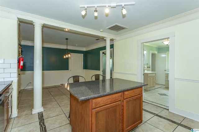 1647 Moncrief Rd, Gardendale, AL 35071 - kitchen featuring decorative columns, light tile patterned floors, dark countertops, ornamental molding, and a center island