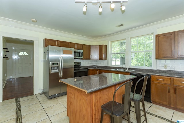 1647 Moncrief Rd, Gardendale, AL 35071 - kitchen featuring black appliances, a sink, decorative backsplash, light tile patterned floors, and crown molding