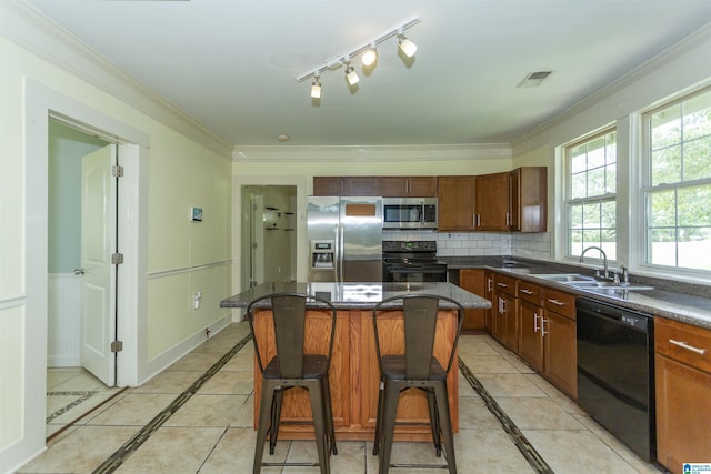 1647 Moncrief Rd, Gardendale, AL 35071 - kitchen featuring black appliances, a sink, inlaid floor details, dark countertops, and a breakfast bar