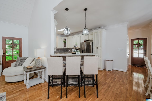 325 Driving Range Rd, Cropwell, AL 35054 - kitchen featuring stainless steel fridge with ice dispenser, light wood finished floors, a peninsula, a kitchen breakfast bar, and decorative backsplash