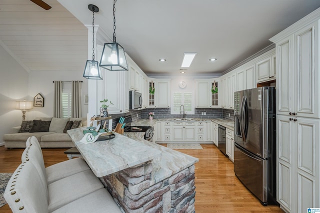 325 Driving Range Rd, Cropwell, AL 35054 - kitchen with appliances with stainless steel finishes, light stone countertops, tasteful backsplash, pendant lighting, and light wood-style flooring