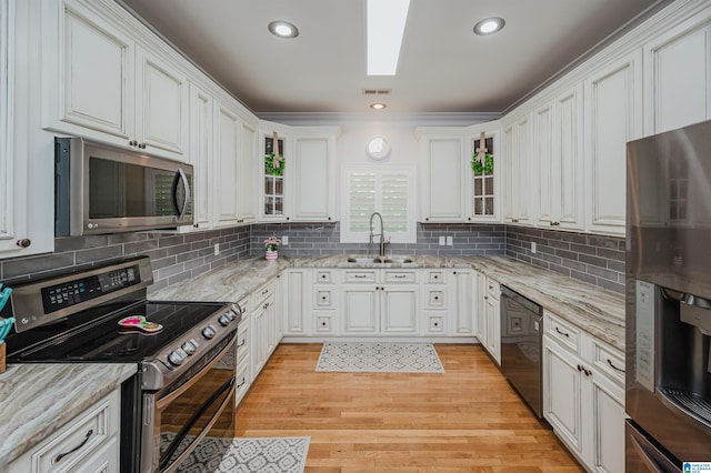 325 Driving Range Rd, Cropwell, AL 35054 - kitchen featuring stainless steel appliances, a sink, white cabinets, glass insert cabinets, and ornamental molding