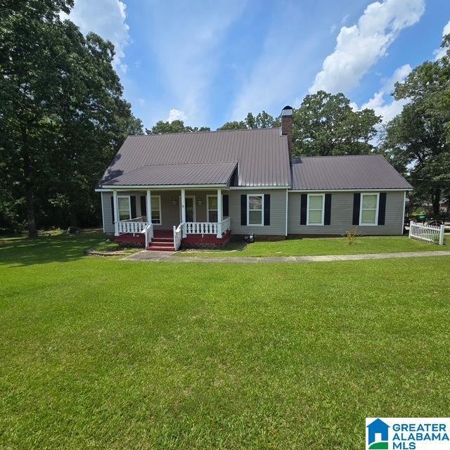 7871 Barbara Dr, Mccalla, AL 35111 - view of front of property featuring a porch, a chimney, a front lawn, and metal roof
