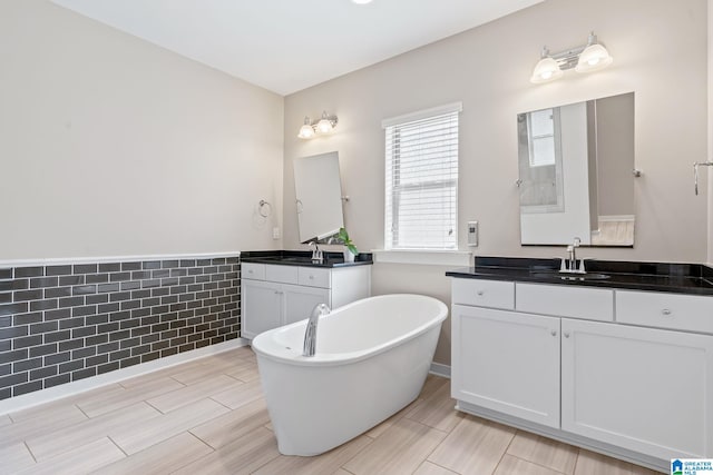 5182 Park Side Cir, Hoover, AL 35244 - bathroom with a freestanding bath, two vanities, and wood finish floors