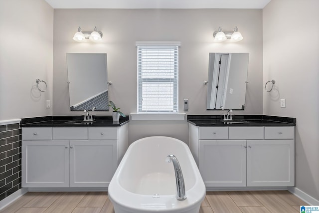 5182 Park Side Cir, Hoover, AL 35244 - bathroom with two vanities, a soaking tub, and wood finished floors