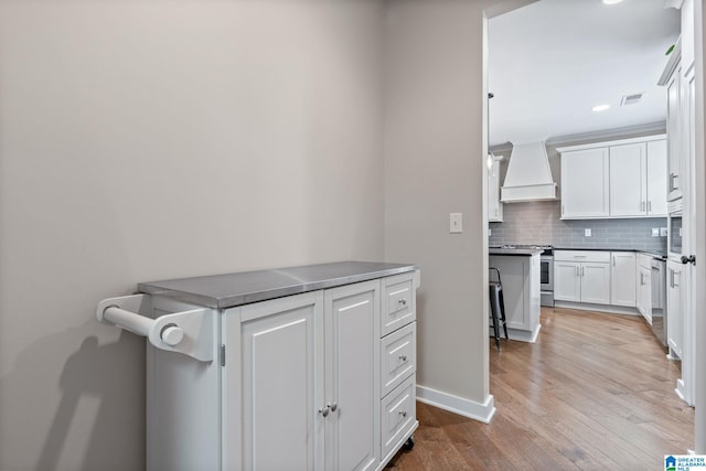 5182 Park Side Cir, Hoover, AL 35244 - kitchen with custom range hood, appliances with stainless steel finishes, wood finished floors, backsplash, and white cabinets