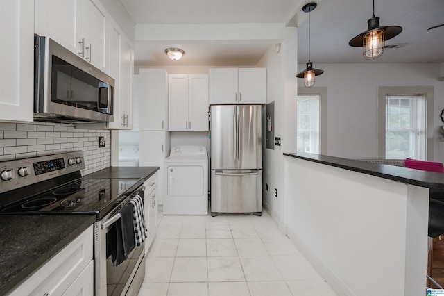 1319 17th St S, Birmingham, AL 35205 - kitchen featuring appliances with stainless steel finishes, washer / clothes dryer, dark countertops, backsplash, and a peninsula