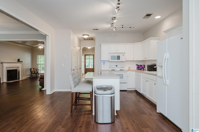 1166 Eagle Dr, Maylene, AL 35114 - kitchen featuring white appliances, a kitchen breakfast bar, a center island, white cabinets, and dark wood-type flooring