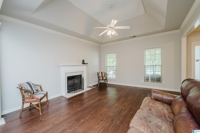 1166 Eagle Dr, Maylene, AL 35114 - living area featuring a tray ceiling, wood finished floors, a fireplace with raised hearth, ceiling fan, and crown molding
