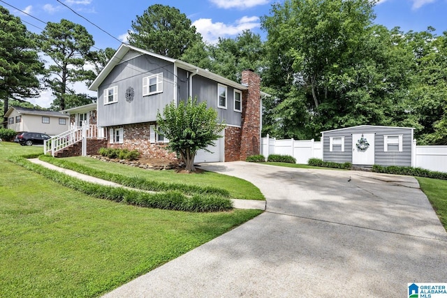 3303 Carousel Dr, Fultondale, AL 35068 - view of front of house with concrete driveway, brick siding, a chimney, an outdoor structure, and an attached garage