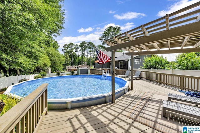 3303 Carousel Dr, Fultondale, AL 35068 - view of pool with a wooden deck, a pergola, a storage unit, and view of wooded area
