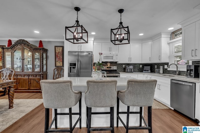 3303 Carousel Dr, Fultondale, AL 35068 - kitchen with appliances with stainless steel finishes, backsplash, a breakfast bar area, ornamental molding, and recessed lighting