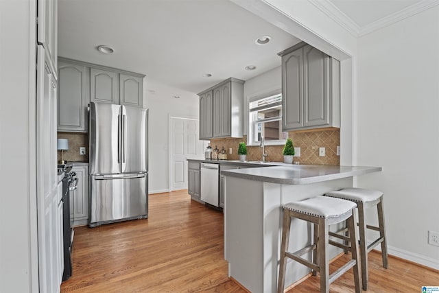 326 Lathrop Ave, Homewood, AL 35209 - kitchen with appliances with stainless steel finishes, gray cabinetry, a peninsula, crown molding, and a breakfast bar