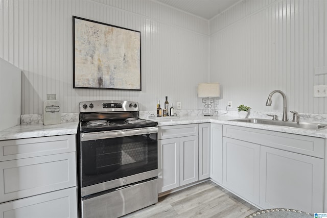 326 Lathrop Ave, Homewood, AL 35209 - kitchen with stainless steel range with electric cooktop, light wood-style floors, and light stone counters