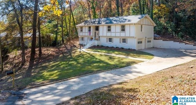 3583 Valley Cir, Vestavia Hills, AL 35243 - view of front facade featuring driveway, a garage, a front lawn, and a view of trees