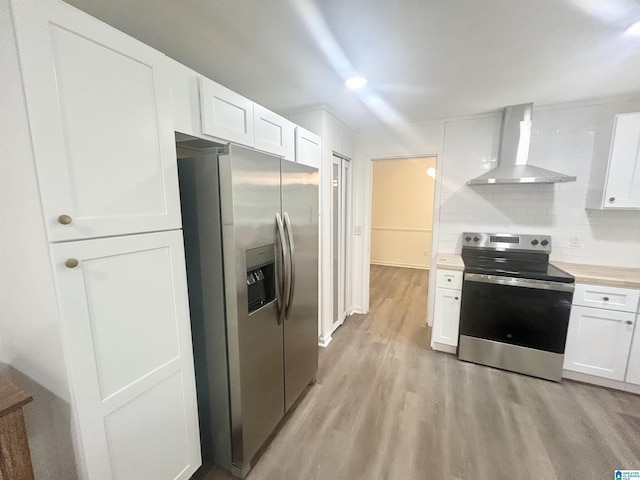 3583 Valley Cir, Vestavia Hills, AL 35243 - kitchen with appliances with stainless steel finishes, wall chimney exhaust hood, light wood-style flooring, white cabinetry, and light countertops