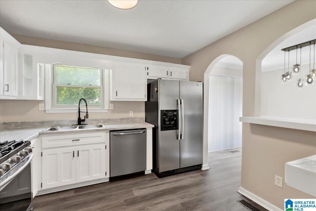 2009 Palmer Ave, Leeds, AL 35094 - kitchen with stainless steel appliances, a sink, white cabinetry, dark wood-style flooring, and light countertops