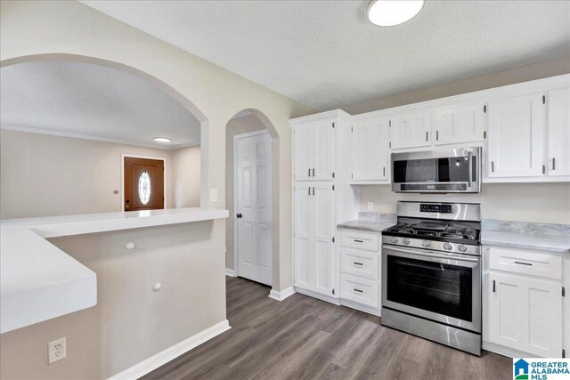 2009 Palmer Ave, Leeds, AL 35094 - kitchen featuring appliances with stainless steel finishes, a textured ceiling, white cabinetry, light countertops, and dark wood-type flooring
