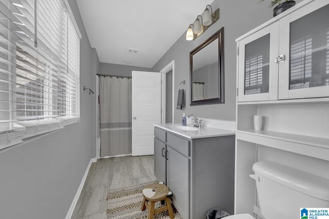 1515 Baxter Ave, Springville, AL 35146 - bathroom featuring toilet, vanity, marble look tile flooring, baseboards, and a shower with curtain