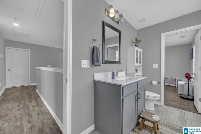1515 Baxter Ave, Springville, AL 35146 - bathroom with vanity, toilet, wood finished floors, and baseboards