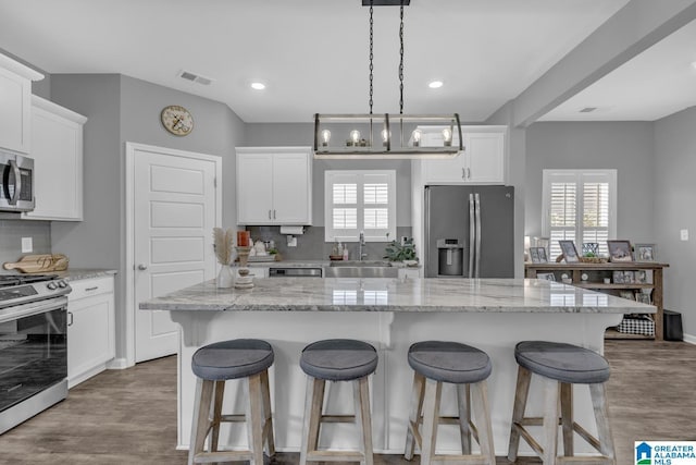 1515 Baxter Ave, Springville, AL 35146 - kitchen with appliances with stainless steel finishes, a sink, a breakfast bar area, plenty of natural light, and recessed lighting