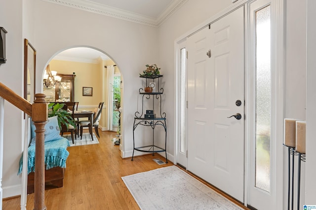 1963 Russet Hill Ln, Hoover, AL 35244 - entrance foyer with arched walkways, crown molding, light wood-style floors, and a chandelier