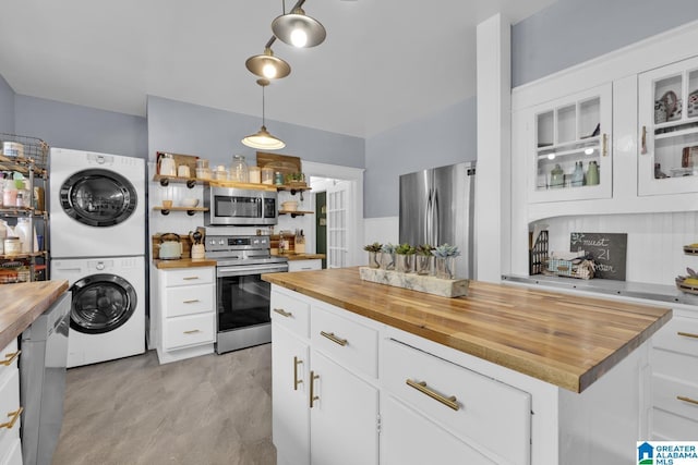 1138 14th Ave S, Birmingham, AL 35205 - kitchen featuring wood counters, stainless steel appliances, estacked washer and dryer, and white cabinets