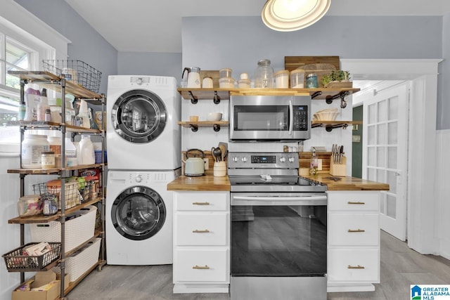 1138 14th Ave S, Birmingham, AL 35205 - kitchen featuring appliances with stainless steel finishes, open shelves, estacked washer and dryer, and butcher block countertops